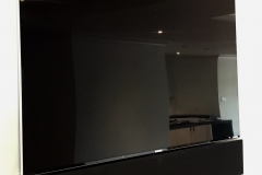 a wall mounted tv with a sonos sound bar