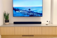 A wall mounted tv with a soundbar